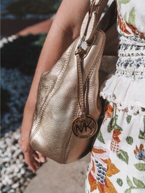 Michael Kors Shimmering Gold Pebbled Leather Shoulder Bag with Logo Charm